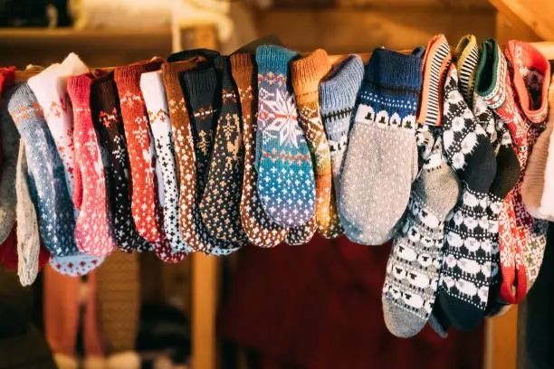 Photo of Knitted Traditional European Warm Clothes - Mittens At Winter Christmas Market. Souvenir From Europe.