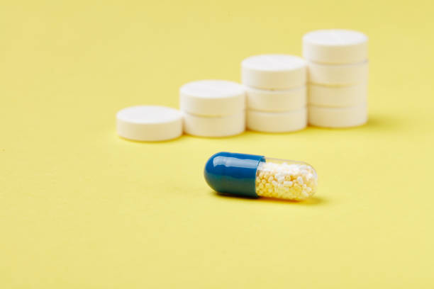 istock Pills in stacks on the yellow background 1003624142