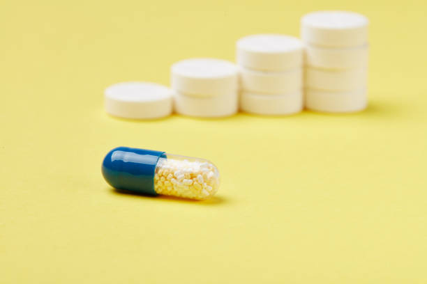 istock Pills in stacks on the yellow background 1003624536