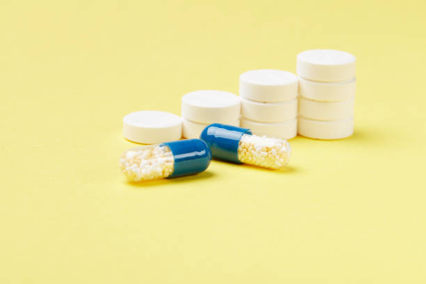 istock Pills in stacks on the yellow background 1003625026