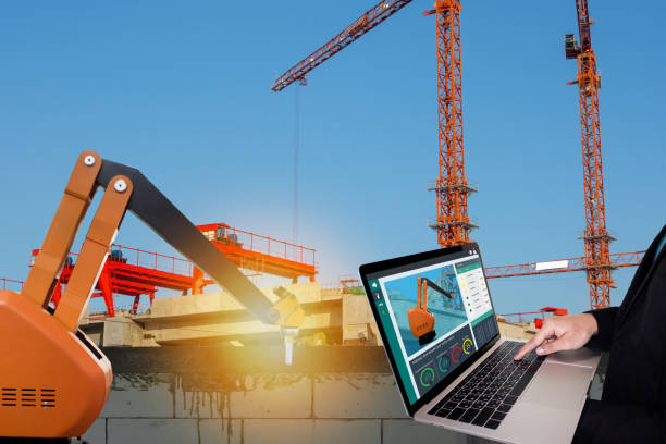 istock iot smart factory , industry 4.0 technology concept, Engineer use computer to monitor, detect and analysis the robot arm for construction filed, Robot arm use to lay brick and plaster wall or factory 1003628878