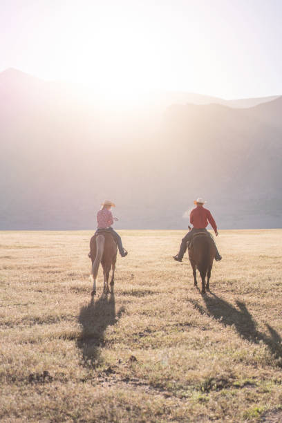 istock Cowboys Horseback Riding at sunrise 1003648784