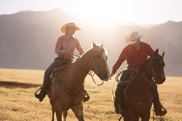istock Cowboys Horseback Riding at sunrise 1003648846