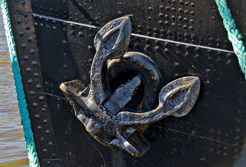 old anchor at the bow of a riveted hulk of an old iron ship at Hamburg, Germany