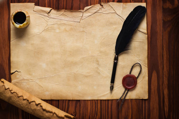 istock White goose feather and inkwell, scroll on the background table 1003673212