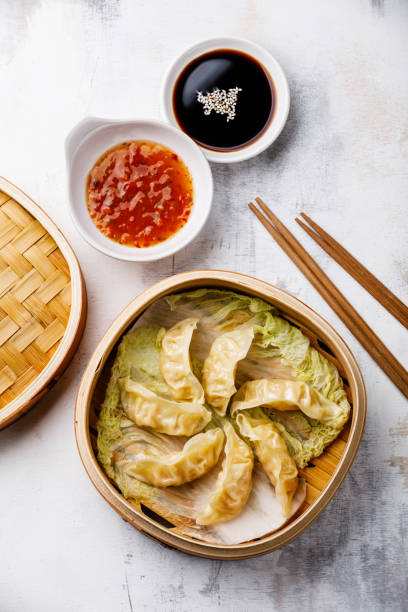 istock Gyoza dumpling in bamboo steamer and sauce 1003675820