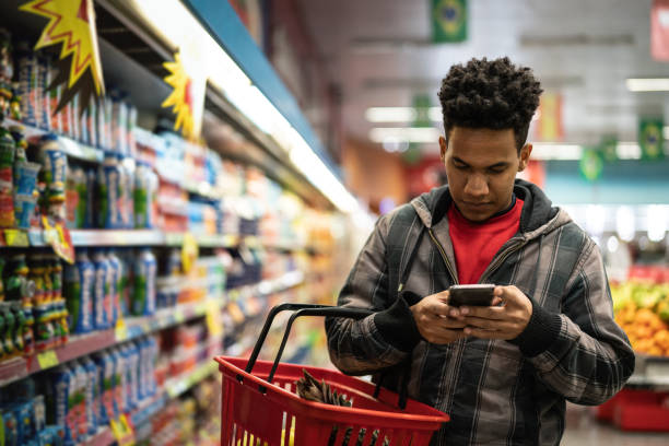 customer buying with mobile app on supermarket - food shopping imagens e fotografias de stock