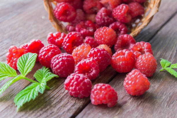 istock fresh raspberries on a wooden table,scattered berries 1003679664