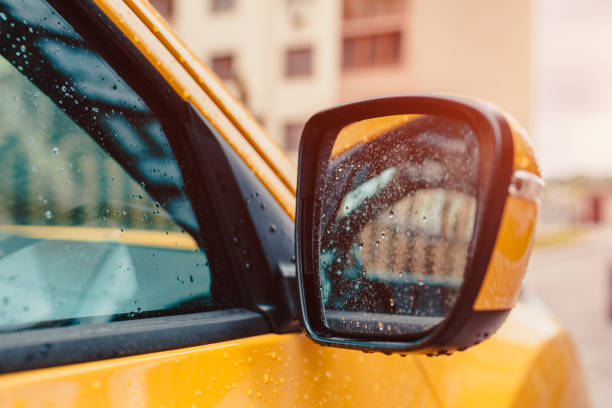 laterales espejo retrovisor de un coche amarillo moderno. agua de lluvia cae sobre el vidrio - rear view mirror car mirror sun fotografías e imágenes de stock
