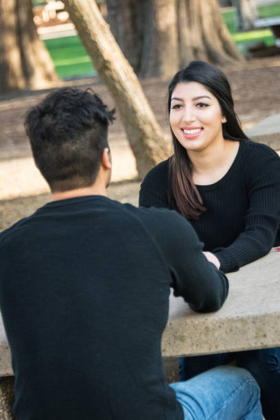 istock Couple talking sitting at the park 1003735210