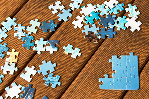Pieces of different puzzles on a wooden table. The concept of thinking development