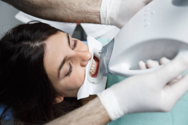 istock Woman in dentist chair doing teeth whitening 1003739290