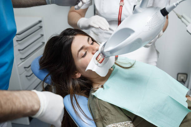 istock Woman in dentist chair doing teeth whitening 1003739344