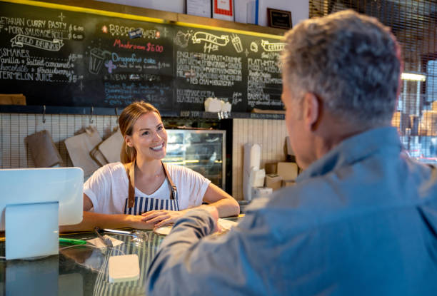 istock Happy woman working at a bakery serving customer 1003743878