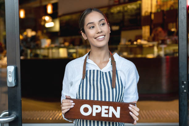 istock Happy waitress holding an open sign at a restaurant 1003743894