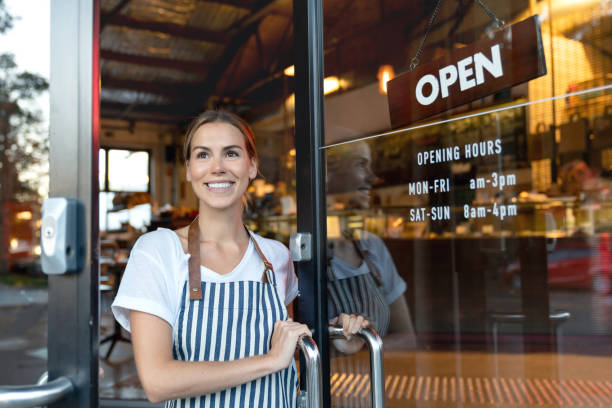 istock Happy waitress opening the door at a cafe 1003743900