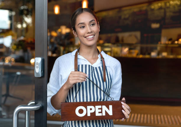 istock Thoughtful business owner holding an open sign at a cafe 1003743940