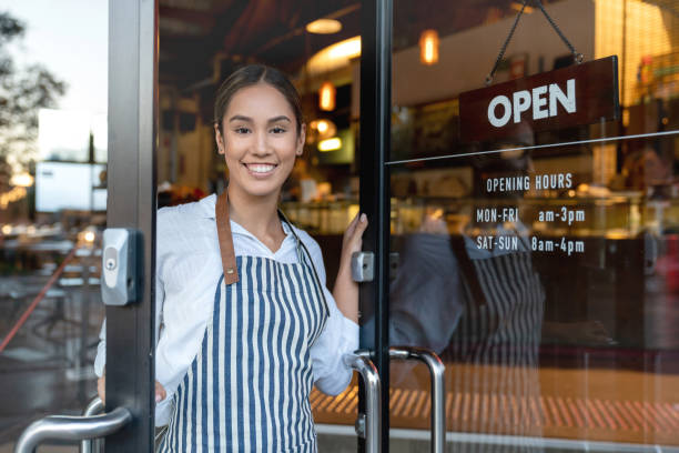 istock Happy waitress opening the door at a restaurant 1003743952