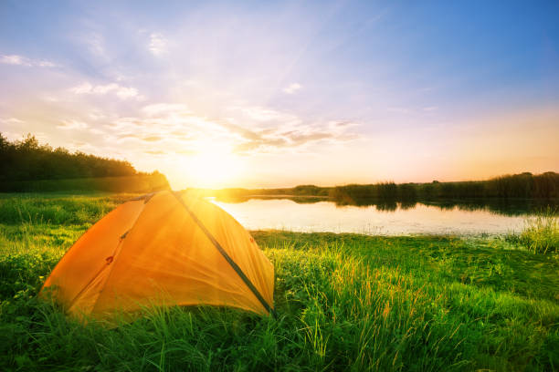 istock Orange tent on the river bank 1003750660