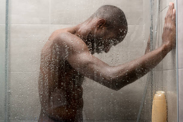 vue latérale du beau jeune homme afro-américain lavage de corps dans la douche - shower portrait male beauty chest photos et images de collection