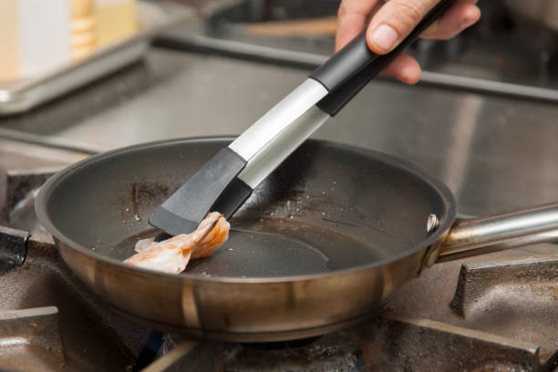 istock The hands of the cook, grilling shrimp 1003755876