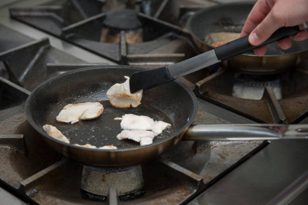 istock Hands cook, fry in a frying pan chicken 1003763336