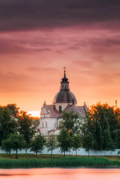 Photo of Nesvizh, Minsk Region, Belarus. Corpus Christi Church At Summer Sunset Evening Or Sunrise Morning. Famous Landmark In Nyasvizh