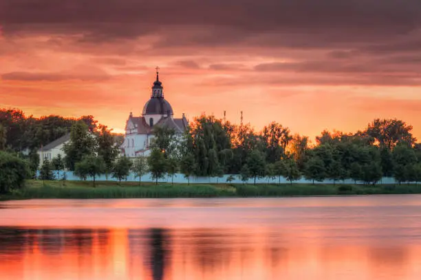 Photo of Nesvizh, Minsk Region, Belarus. Corpus Christi Church At Summer Sunset Evening Or Sunrise Morning. Famous Landmark In Nyasvizh