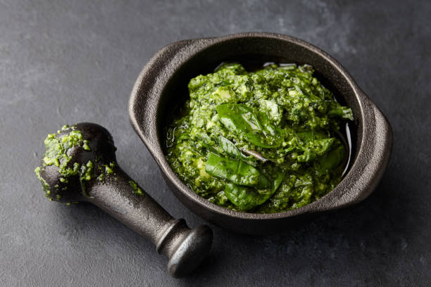 istock Basil pesto sauce in iron mortar, close up view 1003775836
