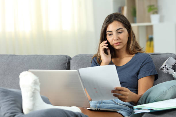 Disabled freelancer working at home Disabled freelancer working calling on phone sitting on a couch in the living room at home recover tab stock pictures, royalty-free photos & images