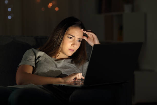 istock Worried woman using a laptop in the night 1003786798
