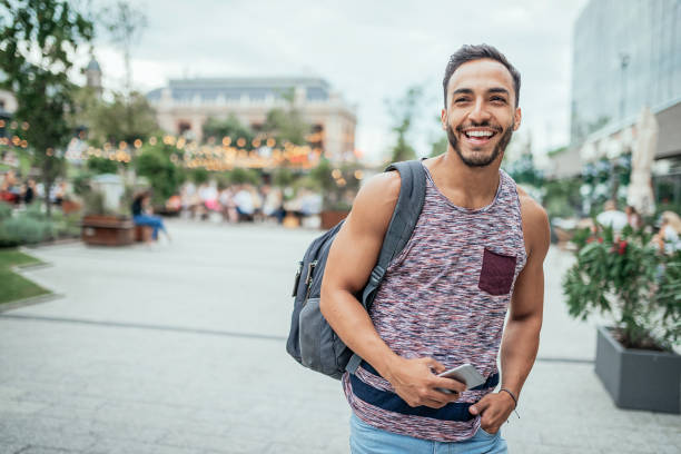 Latino traveler with backpack discovering Europe Portrait of 30 year old backpacker traveler from Latin America, discovering Central Europe in summer man gay stock pictures, royalty-free photos & images