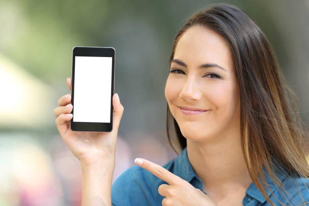 istock Satisfied woman pointing at a blank phone screen 1003787604