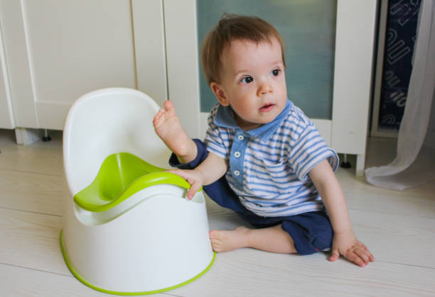 A little boy learns to go potty. Accustom the child to the potty. A little boy learns to go potty. Accustom the child to the potty. accustom stock pictures, royalty-free photos & images