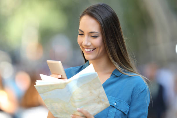 istock Tourist checking destination in a smart phone and map 1003801096