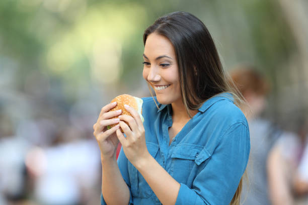 Excited woman ready to eat a burger Excited woman ready to eat a burger on the street spanish hamburger stock pictures, royalty-free photos & images