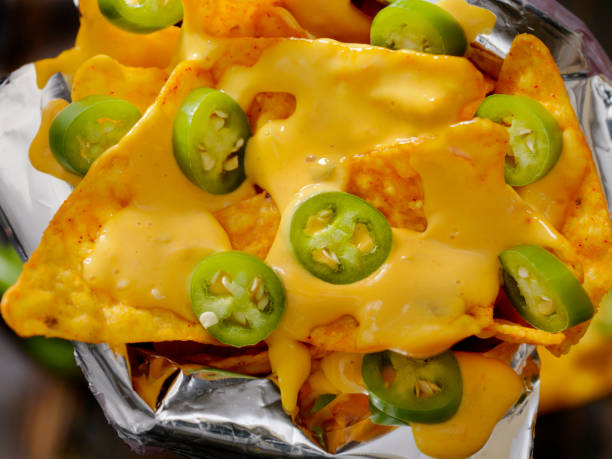 Nacho Tortilla Chips in a bag with Cheese Sauce and Jalapenos Nacho Tortilla Chips in a bag with Cheese Sauce and Jalapenos cheese sauce stock pictures, royalty-free photos & images