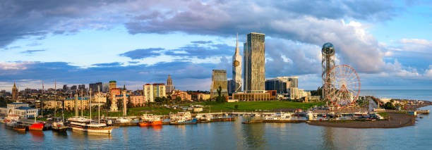 Beautiful Batumi, Georgia in golden summer morning sunlight Beautiful Batumi, Georgian resort city and port at Black Sea – panoramic view of city center from sea in golden summer morning sunlight batumi stock pictures, royalty-free photos & images