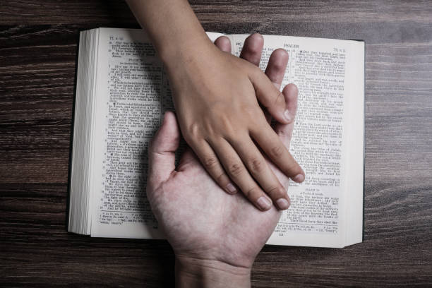 The hands of child and man on the holy bible The hands of child and man on the holy bible. priest photos stock pictures, royalty-free photos & images