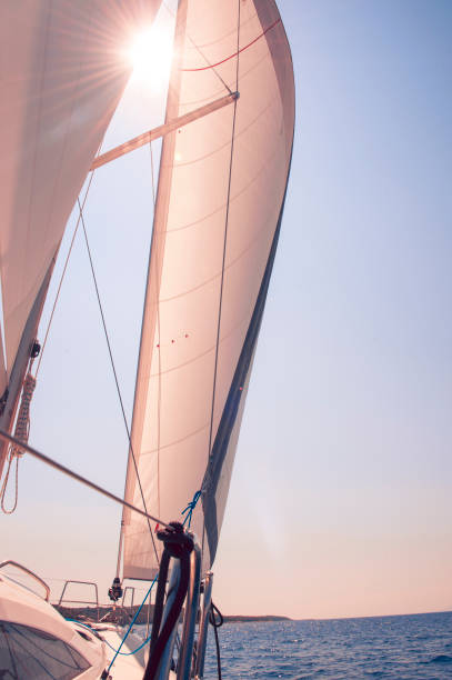 istock Sailboat with sun coming through between the sails. 1003830248