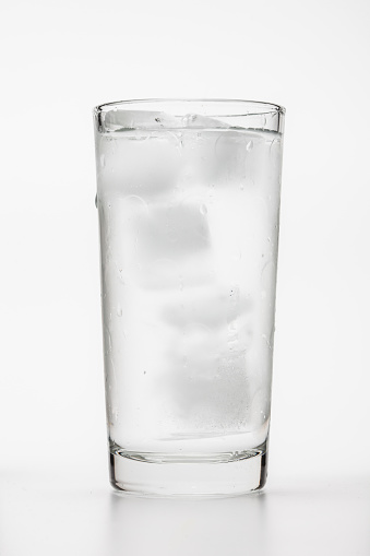 Ice water in the glass on white