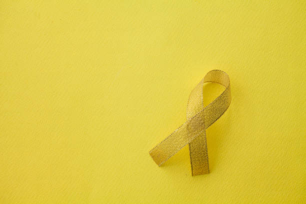 istock Gold ribbon on yellow background 1003845752