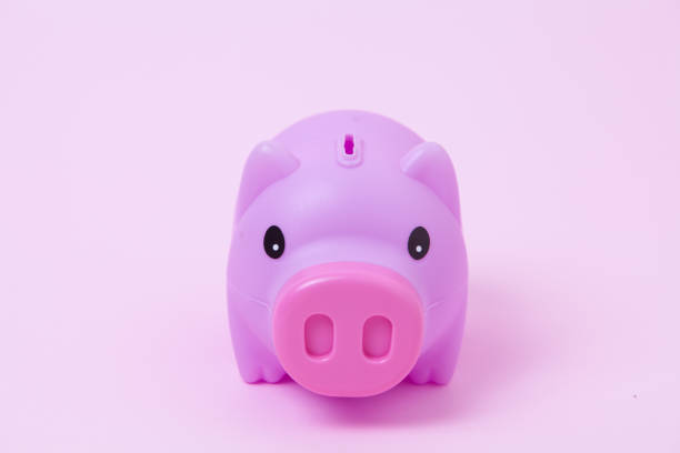 istock Piggy bank on soft pink background 1003860854