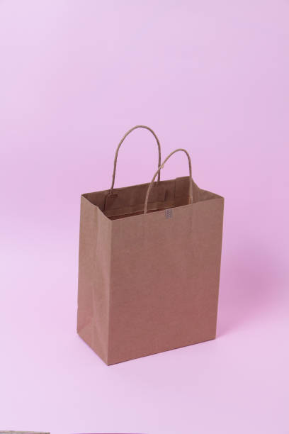 istock Recycle paper bag isolated on pink background 1003860940