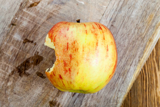 czerwone i żółte jabłko - apple biting missing bite red zdjęcia i obrazy z banku zdjęć