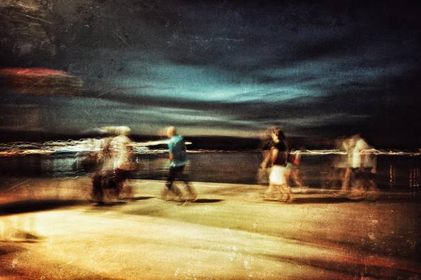 istock Blurred motion view of people walking at the coastline 1003867378