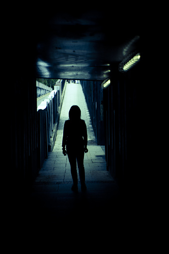 Woman alone and sad in a tunnel. Scene of mystery and desolation