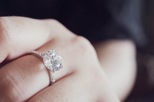 engagement diamond ring on woman finger closeup