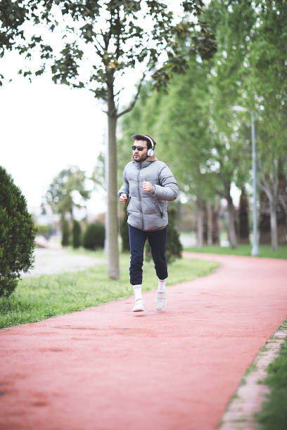 istock Sporty man running up steps in urban setting 1003906556