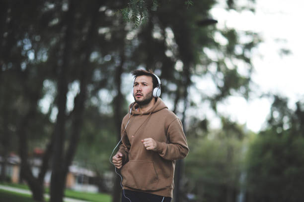 istock Sporty man running up steps in urban setting 1003906742